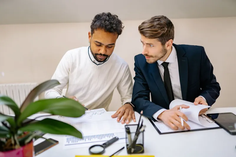 Two consultants going through audit documents at a desk